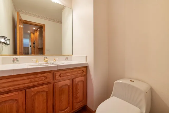 a bathroom with a toilet a sink and mirror