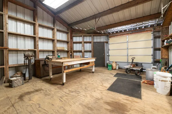 a view of a livingroom with a fireplace a ceiling fan and wooden floor