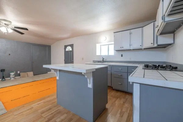 a view of an empty room with wooden floor and closet area