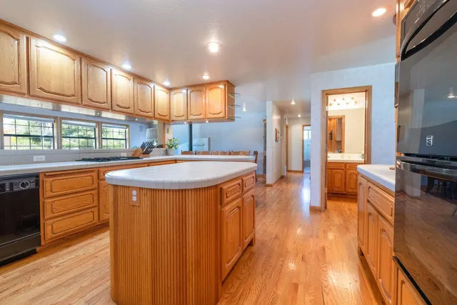 a kitchen with stainless steel appliances granite countertop a sink stove and wooden floor