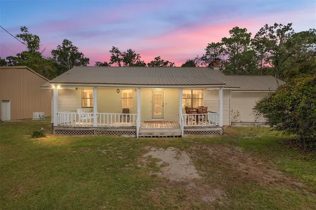 a house view with swimming pool and trees in the background