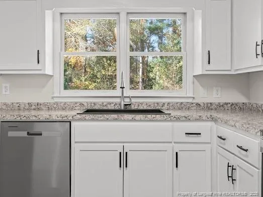 a kitchen with granite countertop white cabinets and a window