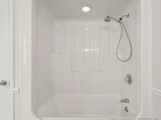 a bathroom with a bath tub with a shower