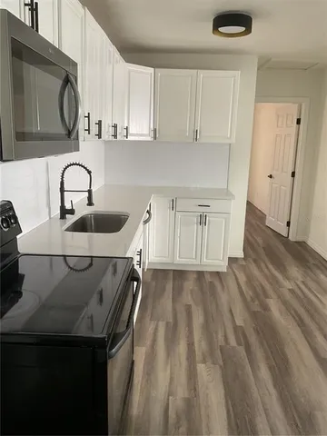 a kitchen with a sink a stove and cabinets