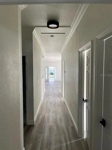 a view of a hallway with wooden floor