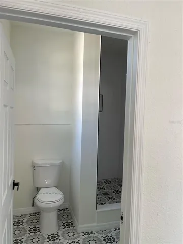 a bathroom with a toilet and a shower