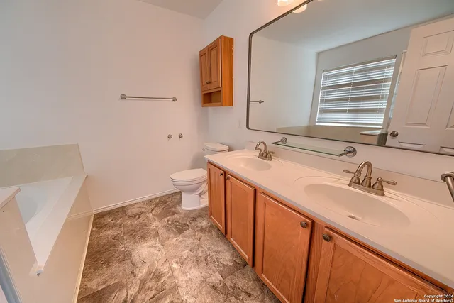 a bathroom with a sink a toilet and mirror