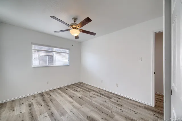 a view of a big room with wooden floor and a ceiling fan