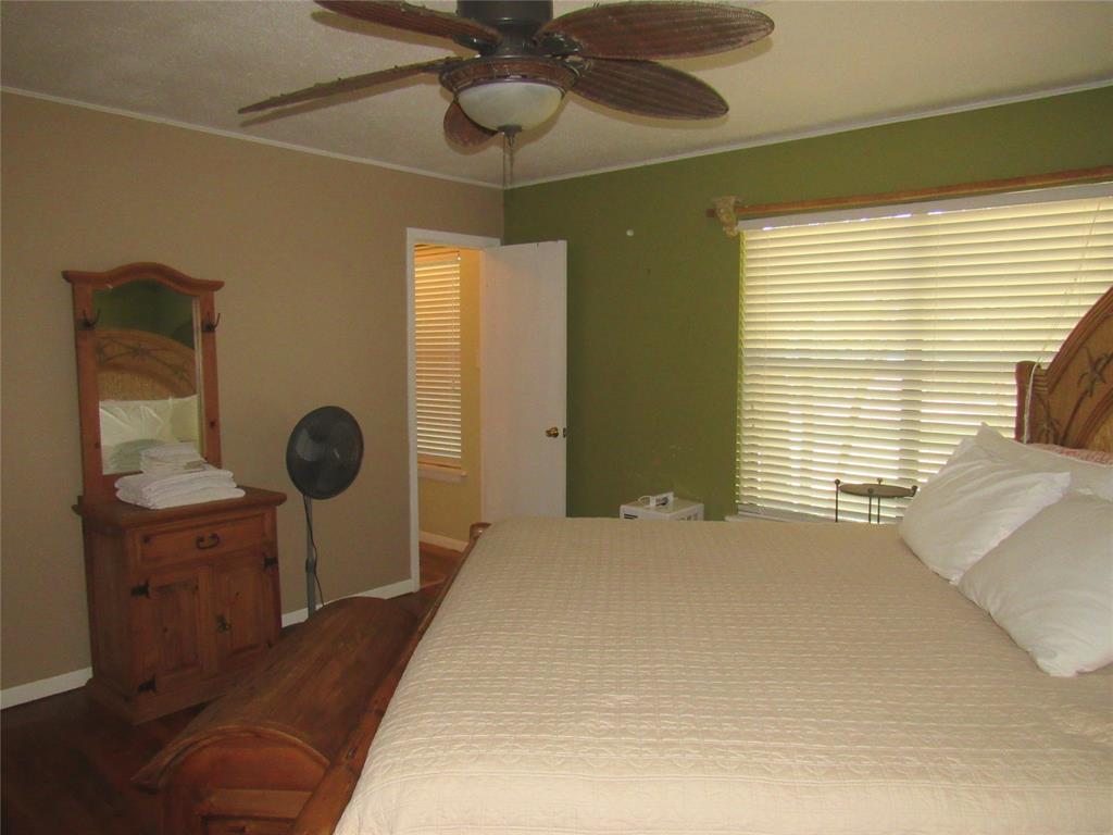 498 Homesite Road Pottsboro, TX 75076 - Photo 16 of 35 a bedroom with a bed and a chandelier