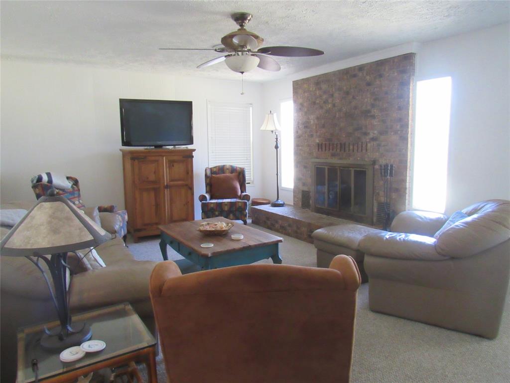 498 Homesite Road Pottsboro, TX 75076 - Photo 8 of 35 a living room with furniture a fireplace and a flat screen tv