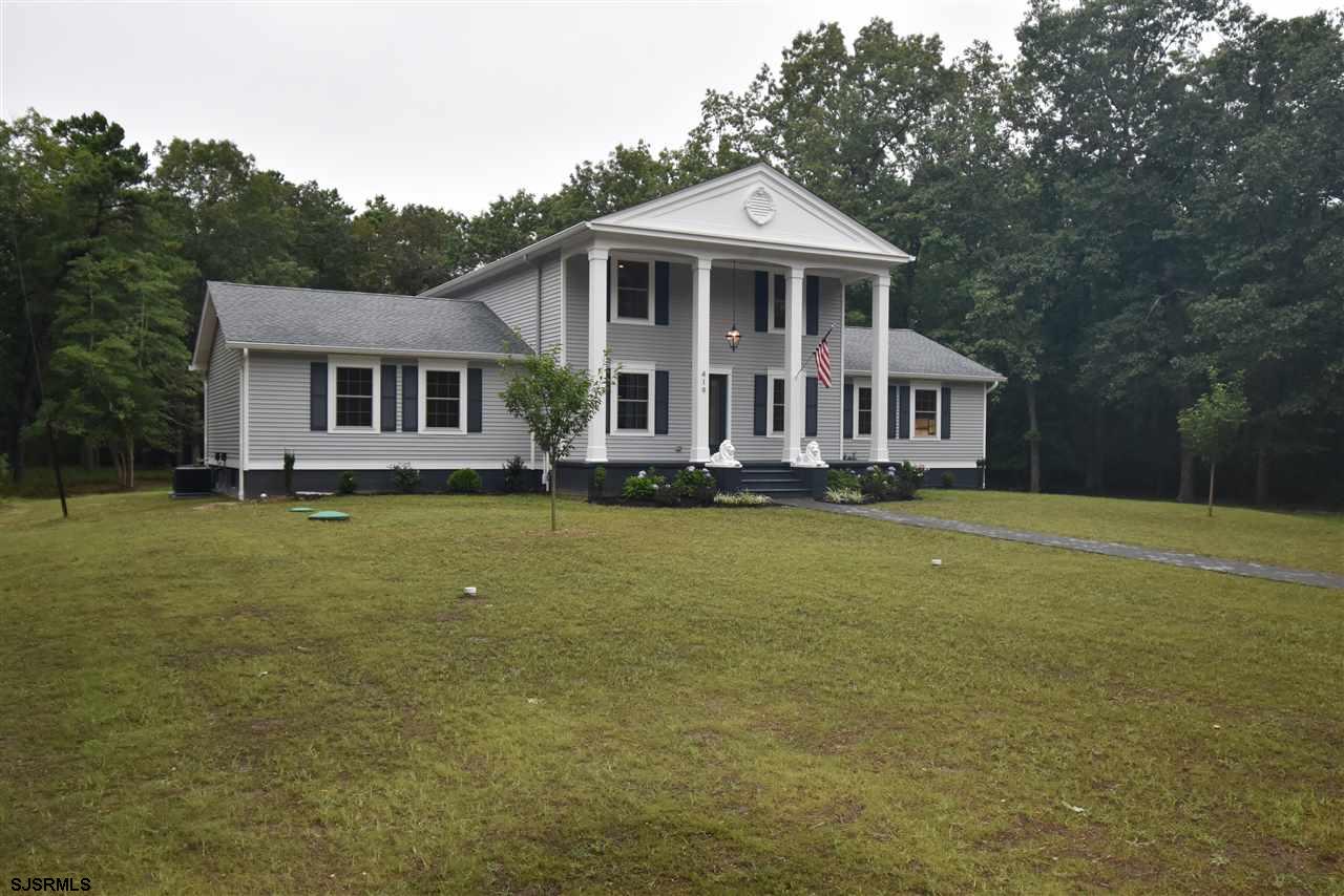 419 Chestnut Neck Road Port Republic, NJ 08241 - Photo 1 of 25 a front view of a house with a yard table and chairs