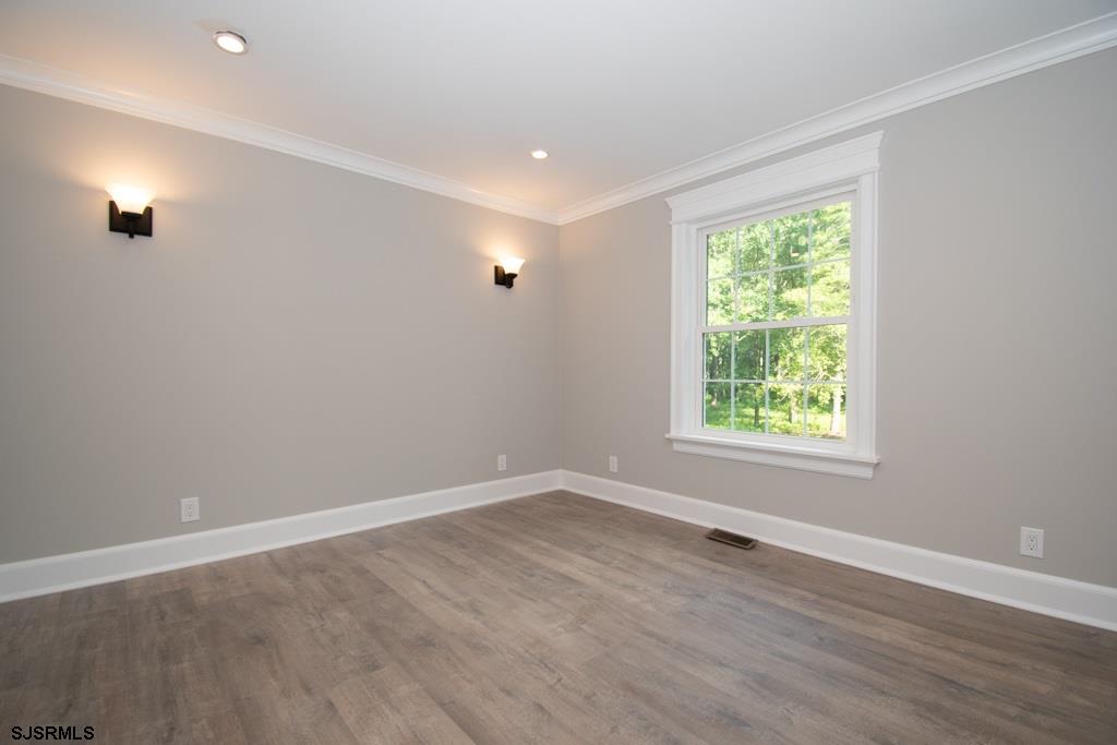 419 Chestnut Neck Road Port Republic, NJ 08241 - Photo 13 of 25 an empty room with wooden floor and windows