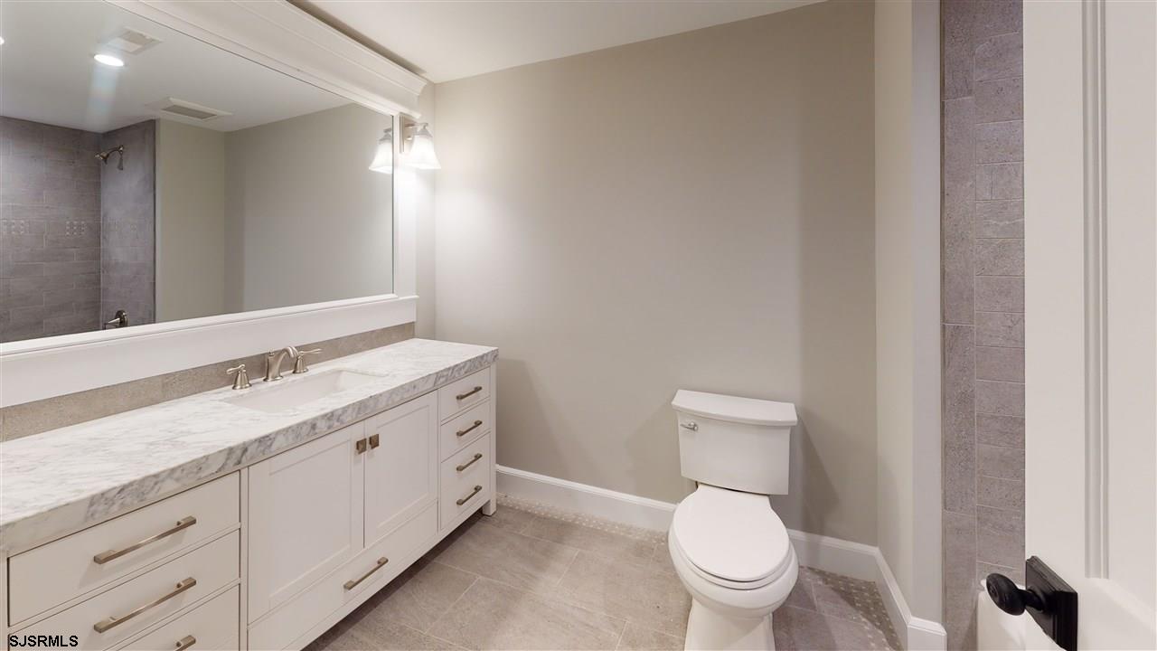419 Chestnut Neck Road Port Republic, NJ 08241 - Photo 19 of 25 a spacious bathroom with a toilet a sink and a mirror