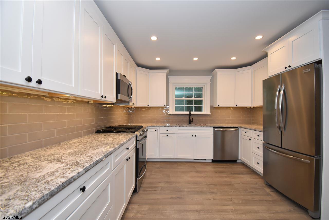 419 Chestnut Neck Road Port Republic, NJ 08241 - Photo 3 of 25 a kitchen with a refrigerator sink and cabinets
