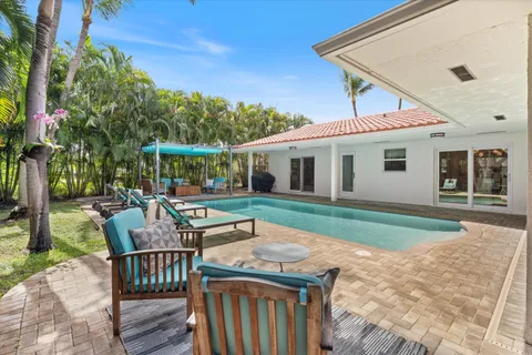 a view of a house with backyard and sitting area