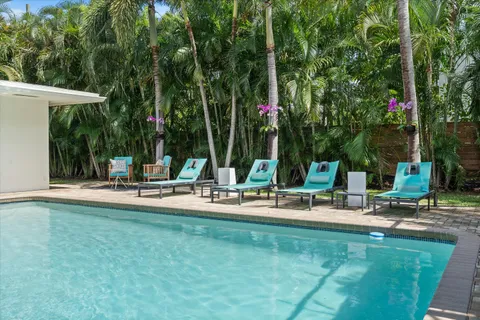 a view of a swimming pool with chairs in patio