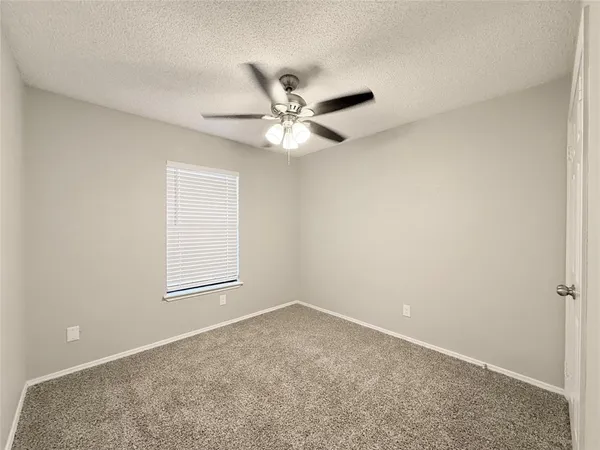 an empty room with a window and a ceiling fan