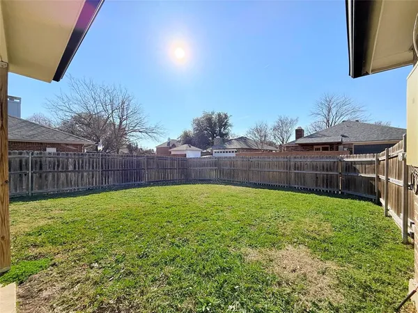 a view of a backyard with wooden fence