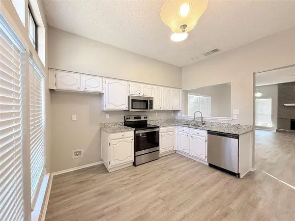 a kitchen with a refrigerator and a stove top oven