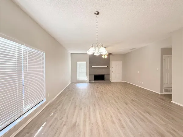 a view of a livingroom with a chandelier wooden floor and a chandelier