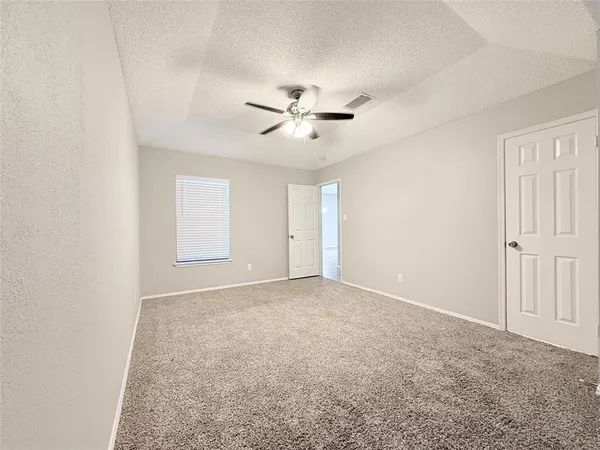an empty room with windows and fan