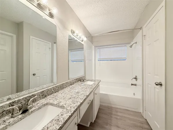 a bath room with a granite countertop sink and a mirror
