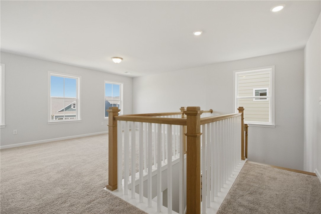 557 Hydrangea Street, Unit LOT 46 Seneca, SC 29678 - Photo 14 of 37 A versatile upper-level space features neutral carpeting, abundant natural light, and a stylish staircase railing.
