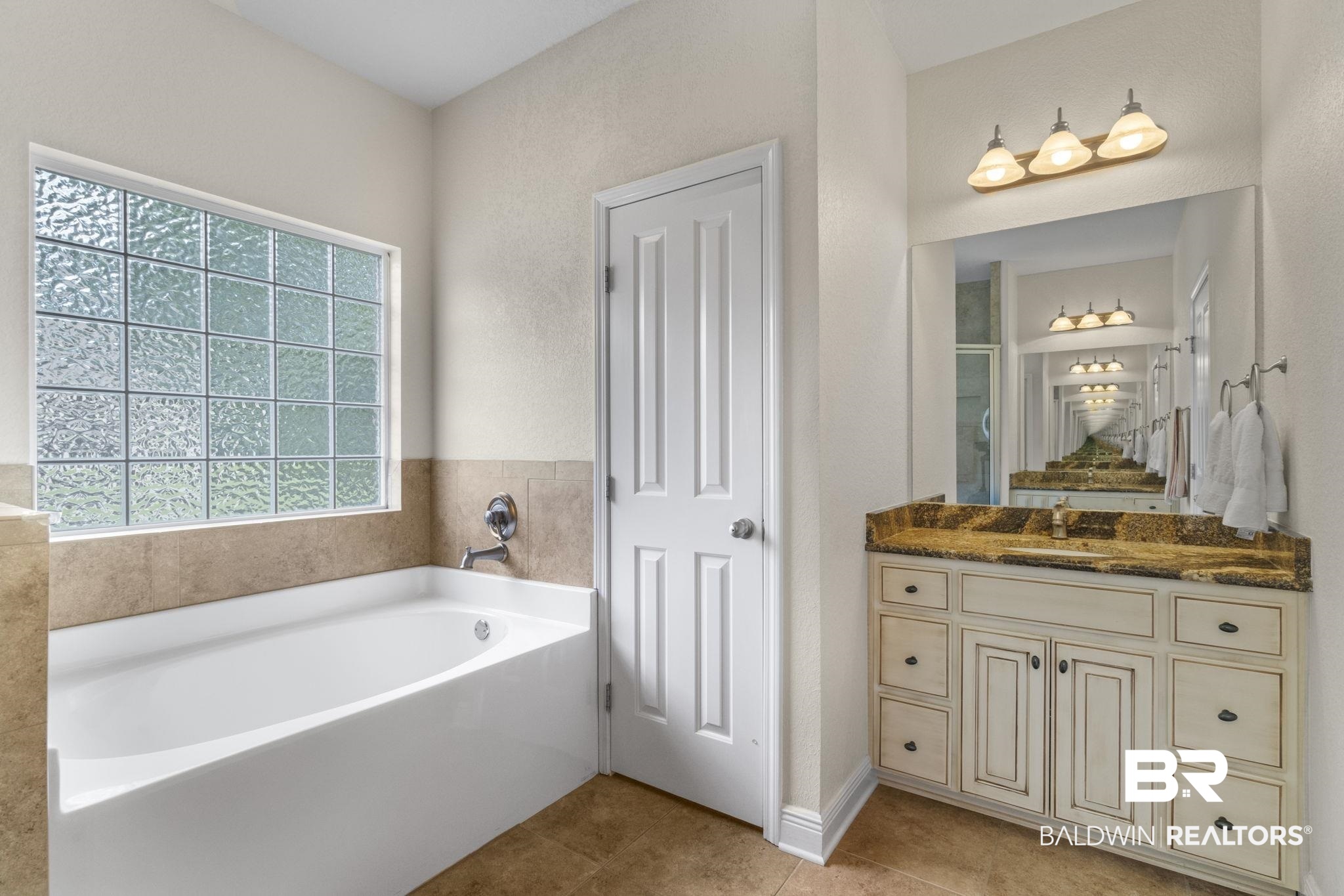 8664 Foxtail Loop Pensacola, FL 32526 - Photo 38 of 64 Full bath with a garden tub, tile patterned flooring, and vanity