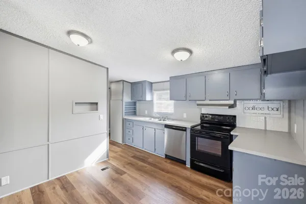 a kitchen with granite countertop a stove top oven and cabinets