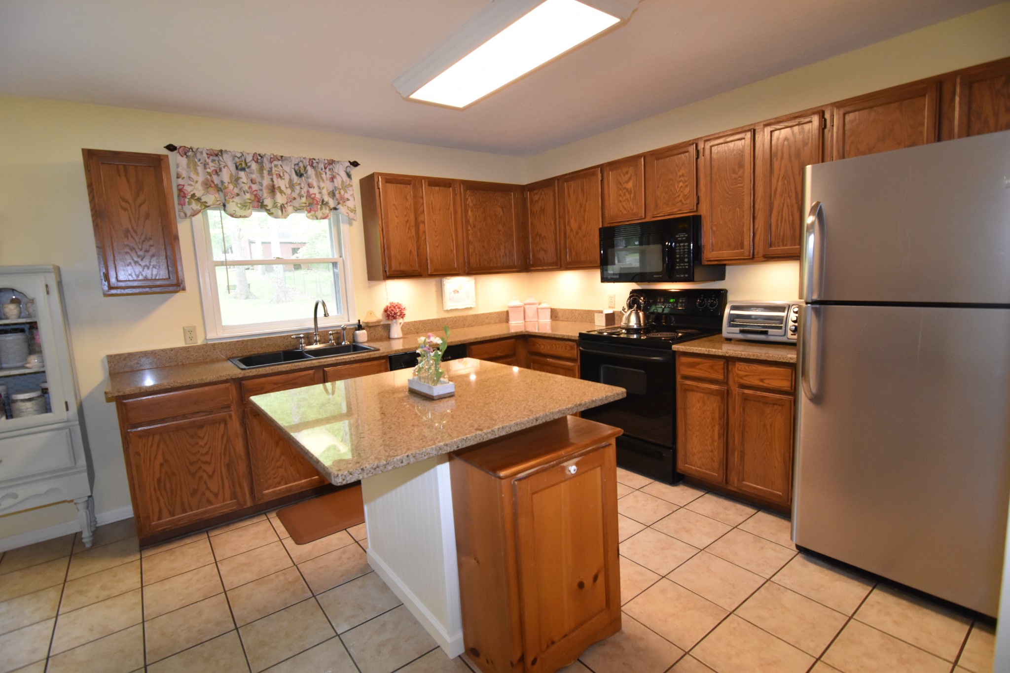 2513 Quarry Road Mount Juliet, TN 37122 - Photo 11 of 42 a kitchen with granite countertop a refrigerator a sink a stove top oven and cabinets