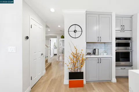 a kitchen with stainless steel appliances kitchen island granite countertop a table chairs in it and wooden floors