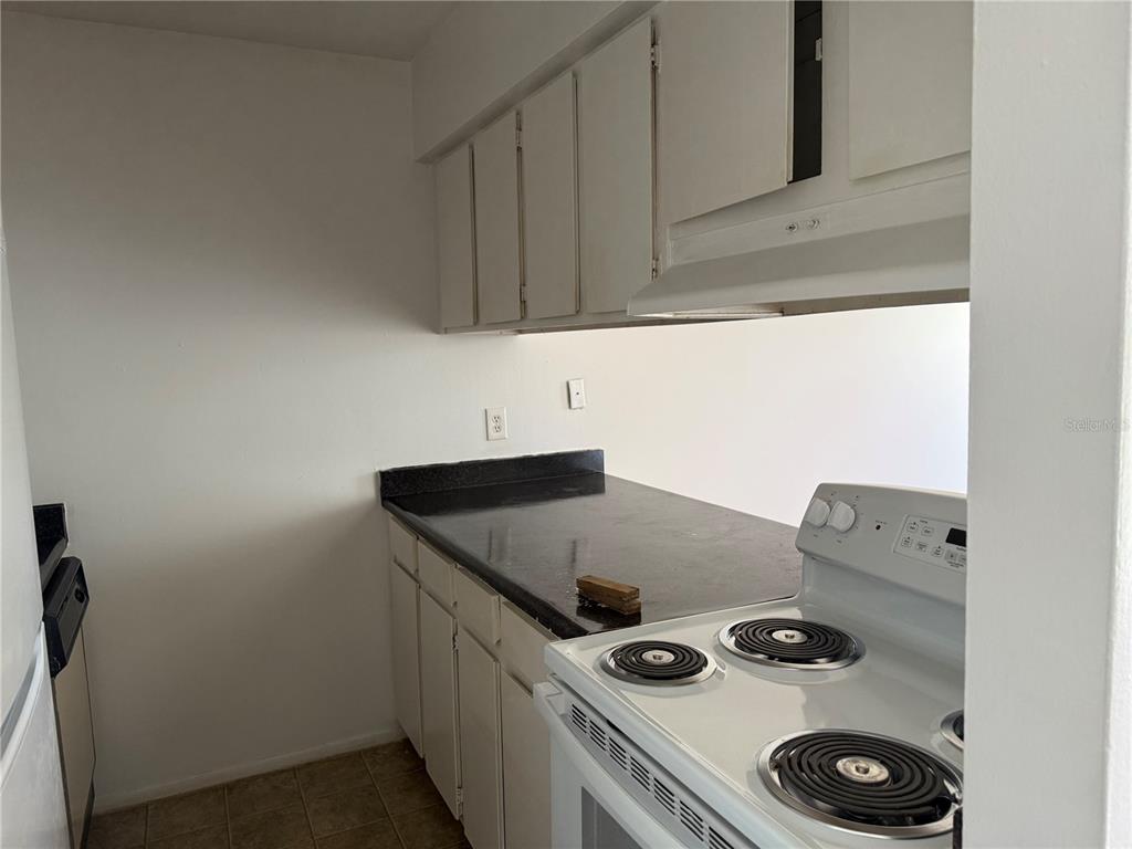 5317 Curry Ford Road, Unit 103 Orlando, FL 32812 - Photo 8 of 10 a kitchen with a stove and cabinets