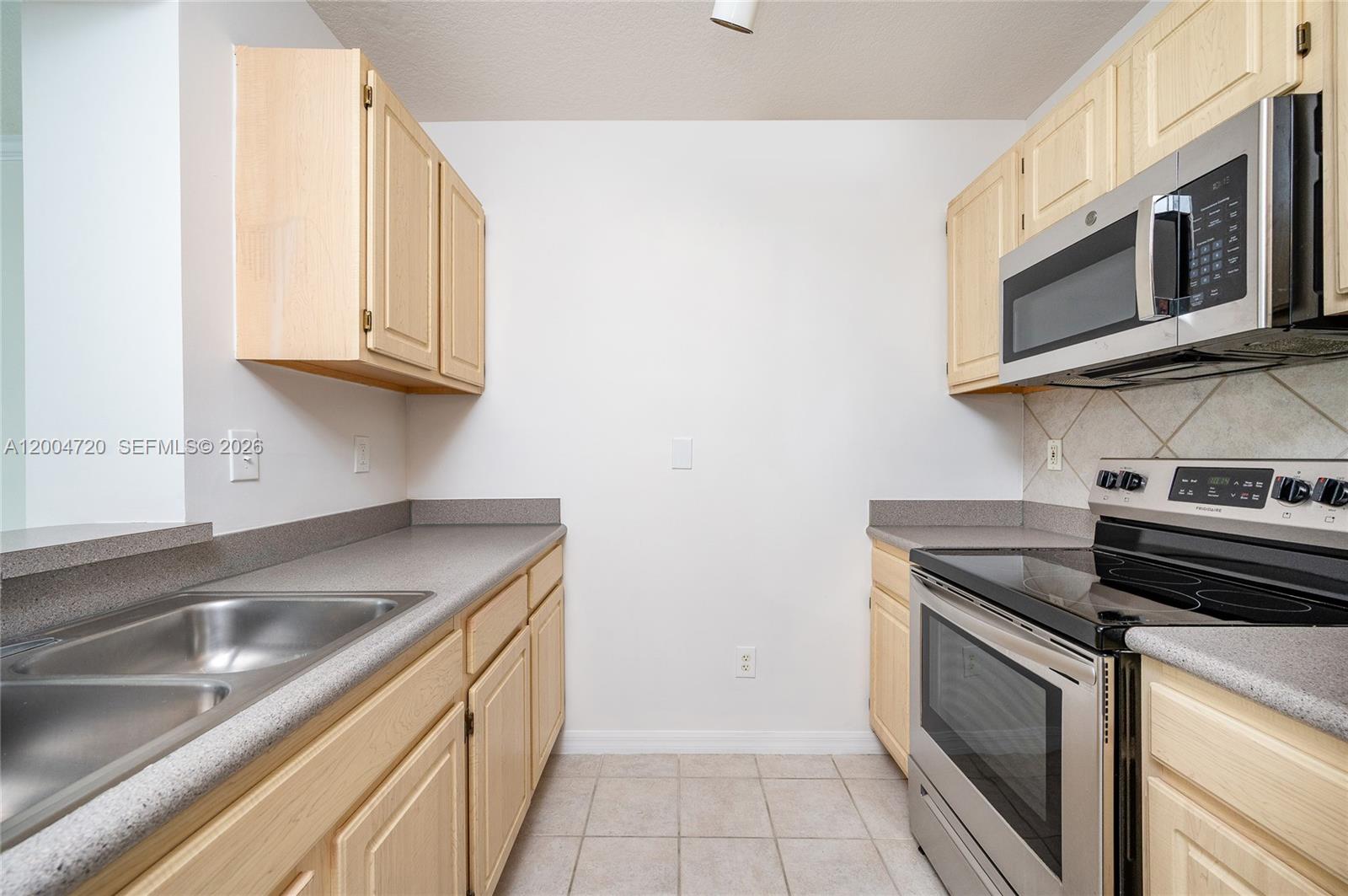 2665 Southwest 37th Avenue, Unit 201 Miami, FL 33133 - Photo 14 of 33 a kitchen with stainless steel appliances granite countertop a sink and a stove