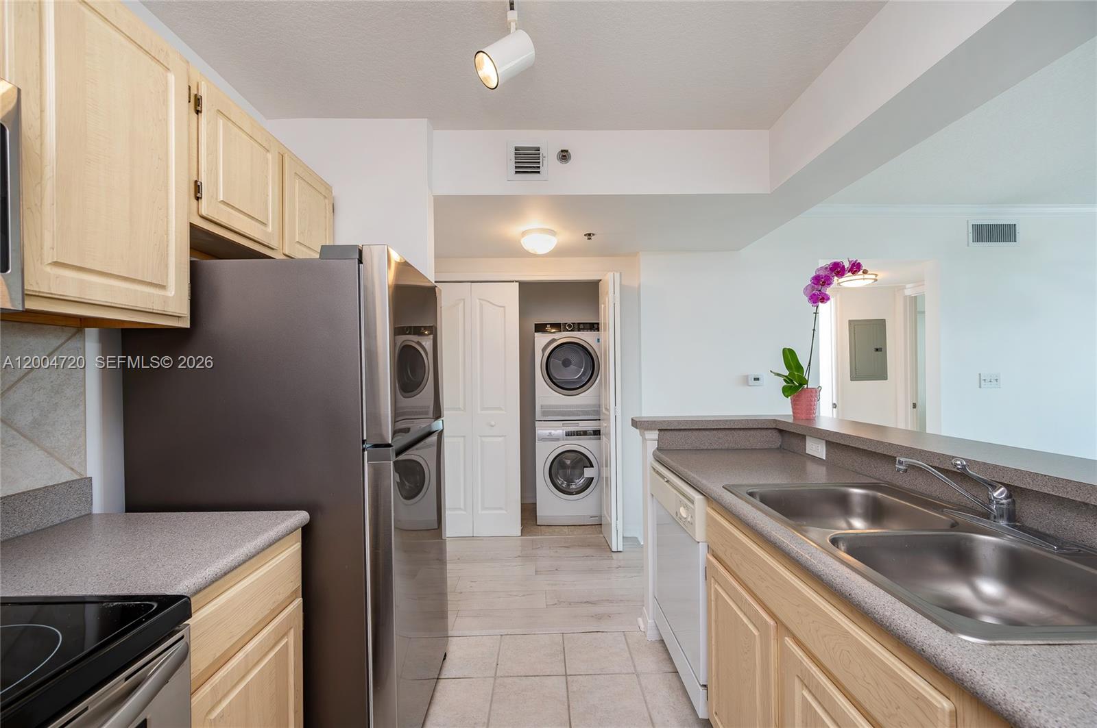 2665 Southwest 37th Avenue, Unit 201 Miami, FL 33133 - Photo 15 of 33 a kitchen with stainless steel appliances granite countertop a sink and a refrigerator