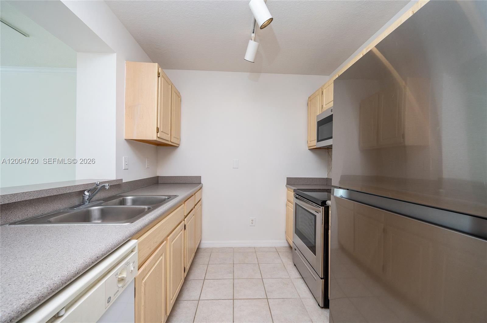 2665 Southwest 37th Avenue, Unit 201 Miami, FL 33133 - Photo 17 of 33 a kitchen with a sink stove and refrigerator