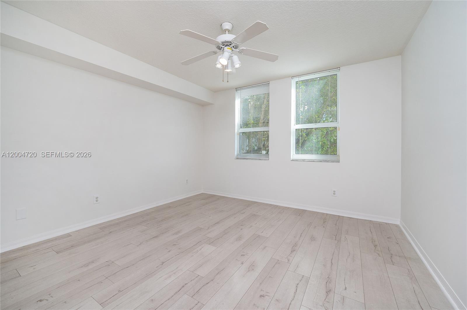 2665 Southwest 37th Avenue, Unit 201 Miami, FL 33133 - Photo 18 of 33 an empty room with wooden floor and windows