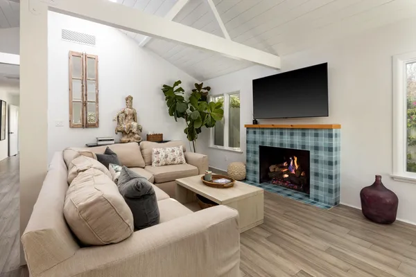 a living room with furniture a fireplace and a flat screen tv