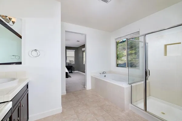 a spacious bathroom with a tub sink and mirror