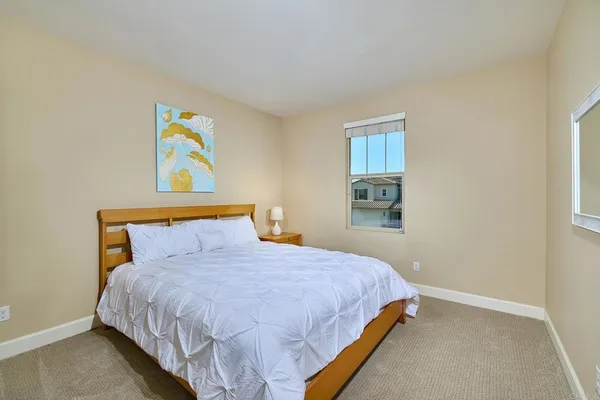 a bedroom with a bed and painting on the wall