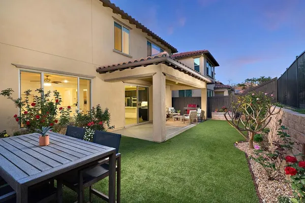 a view of a patio with table and chairs potted plants and a large tree