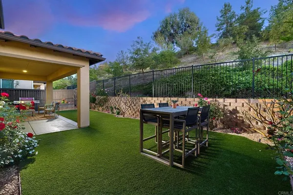 a view of a chair and table in backyard of the house