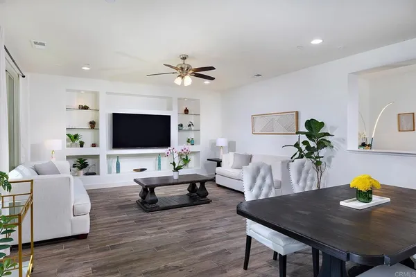 a living room with furniture a flat screen tv and a potted plant