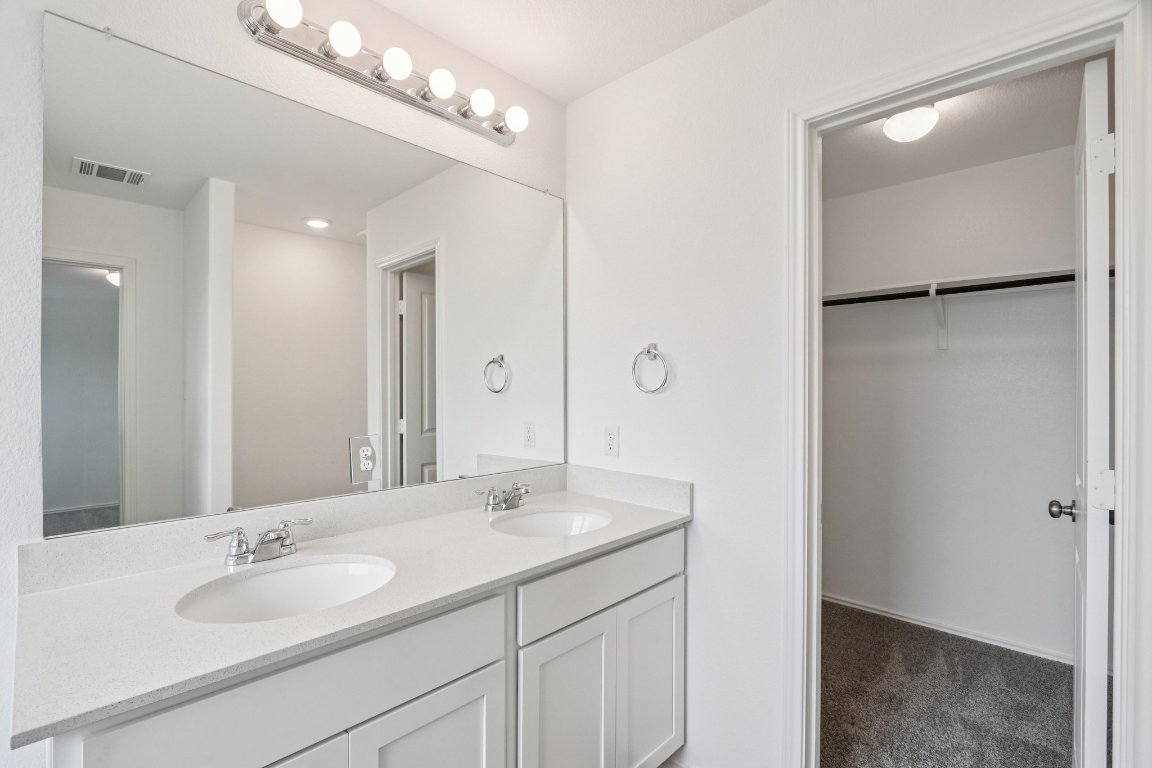 240 Line Of Fire Way Jarrell, TX 76537 - Photo 23 of 33 Bathroom with double vanity and a walk in closet