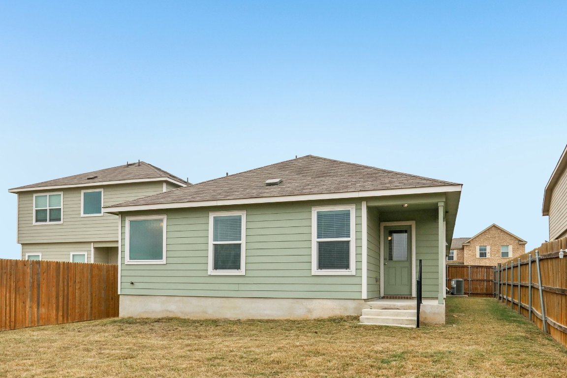 240 Line Of Fire Way Jarrell, TX 76537 - Photo 29 of 33 Rear view of house with a fenced backyard and a shingled roof