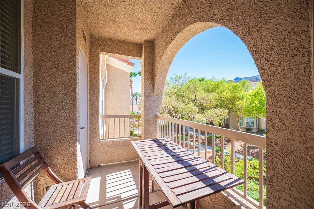 10550 West Alexander Road, Unit 2014 Las Vegas, NV 89129 - Photo 34 of 43 Stucco arches frame views of lush greenery from this private covered balcony.