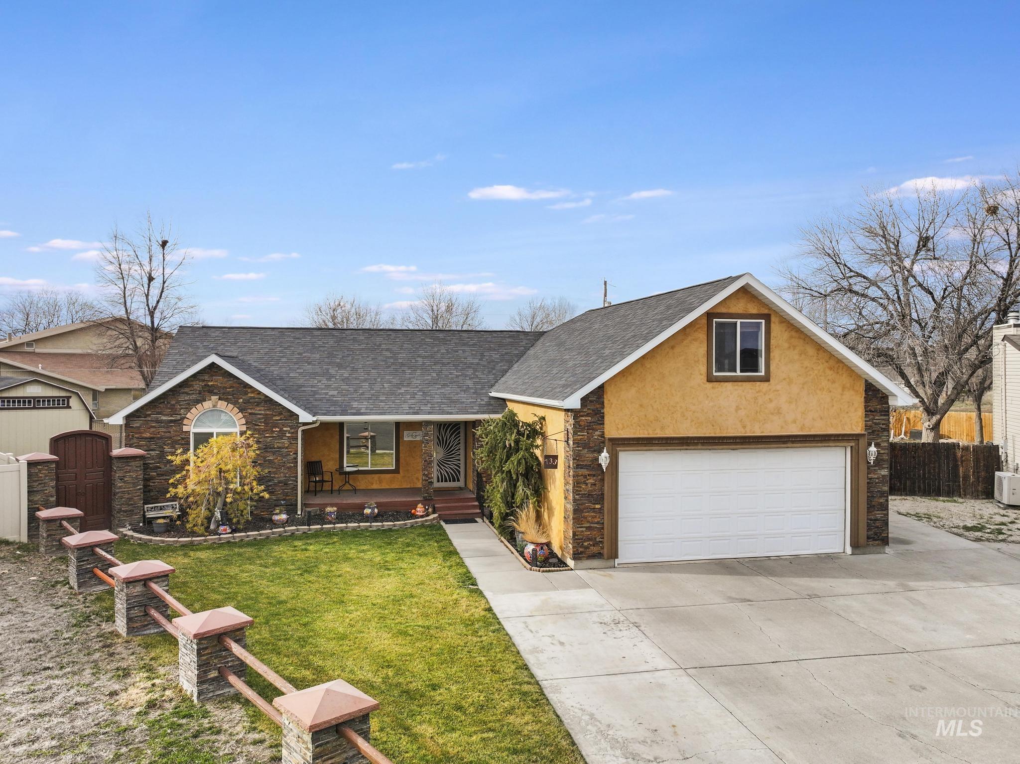 View of front of house featuring a porch, roof with shingles, stucco siding, driveway, and stone siding