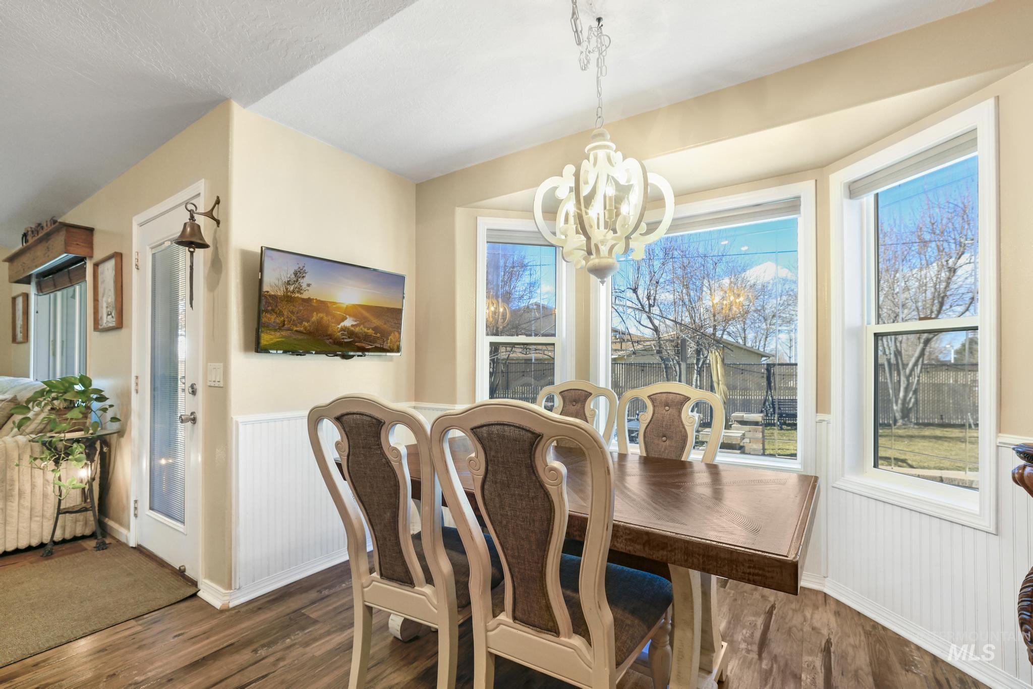 733 Beta Circle Twin Falls, ID 83301 - Photo 11 of 50 Dining room with wainscoting, dark wood finished floors, healthy amount of natural light, and suspended lighting