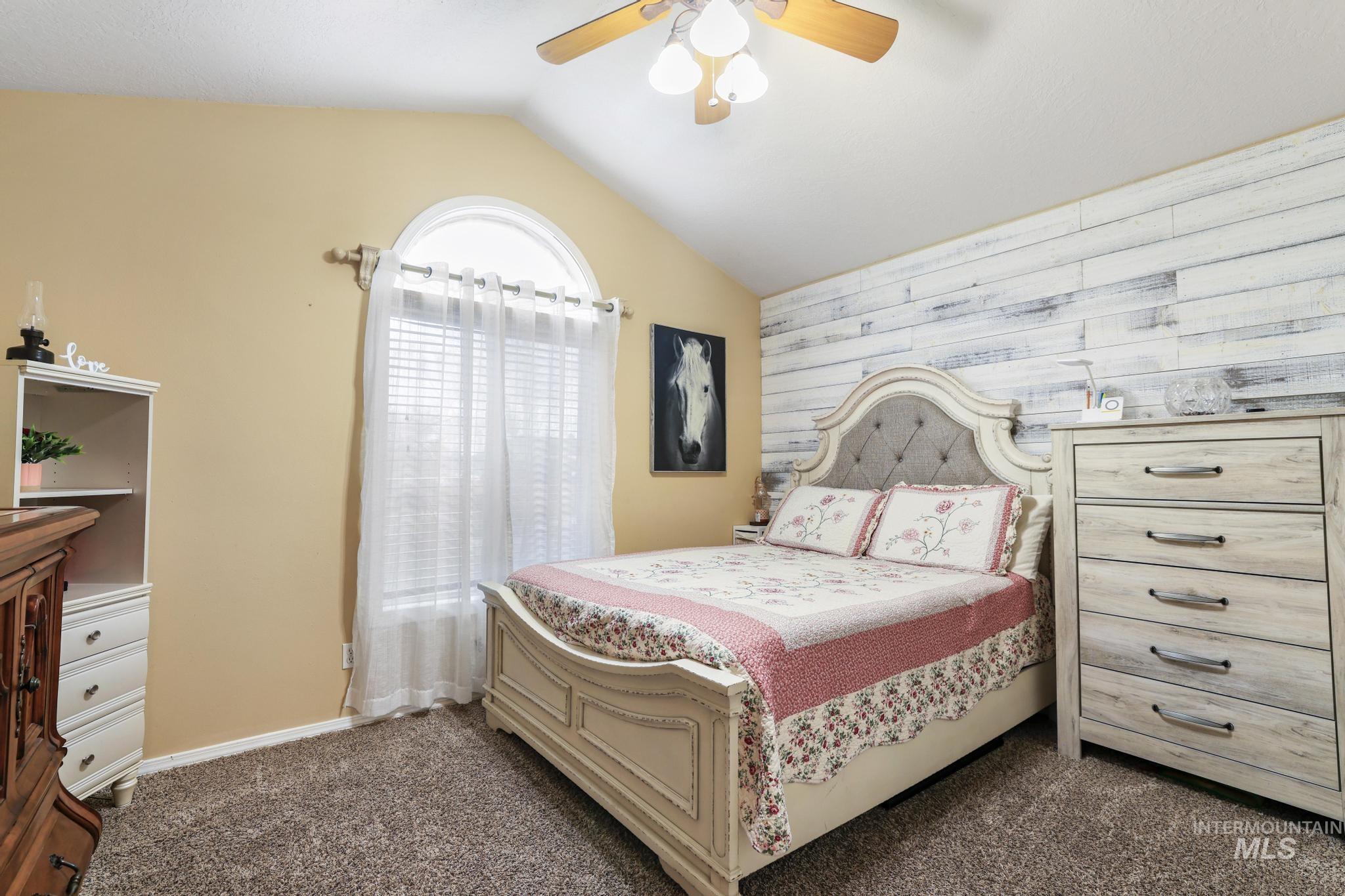 733 Beta Circle Twin Falls, ID 83301 - Photo 14 of 50 Bedroom featuring carpet floors, an accent wall, ceiling fan, lofted ceiling, and wooden walls