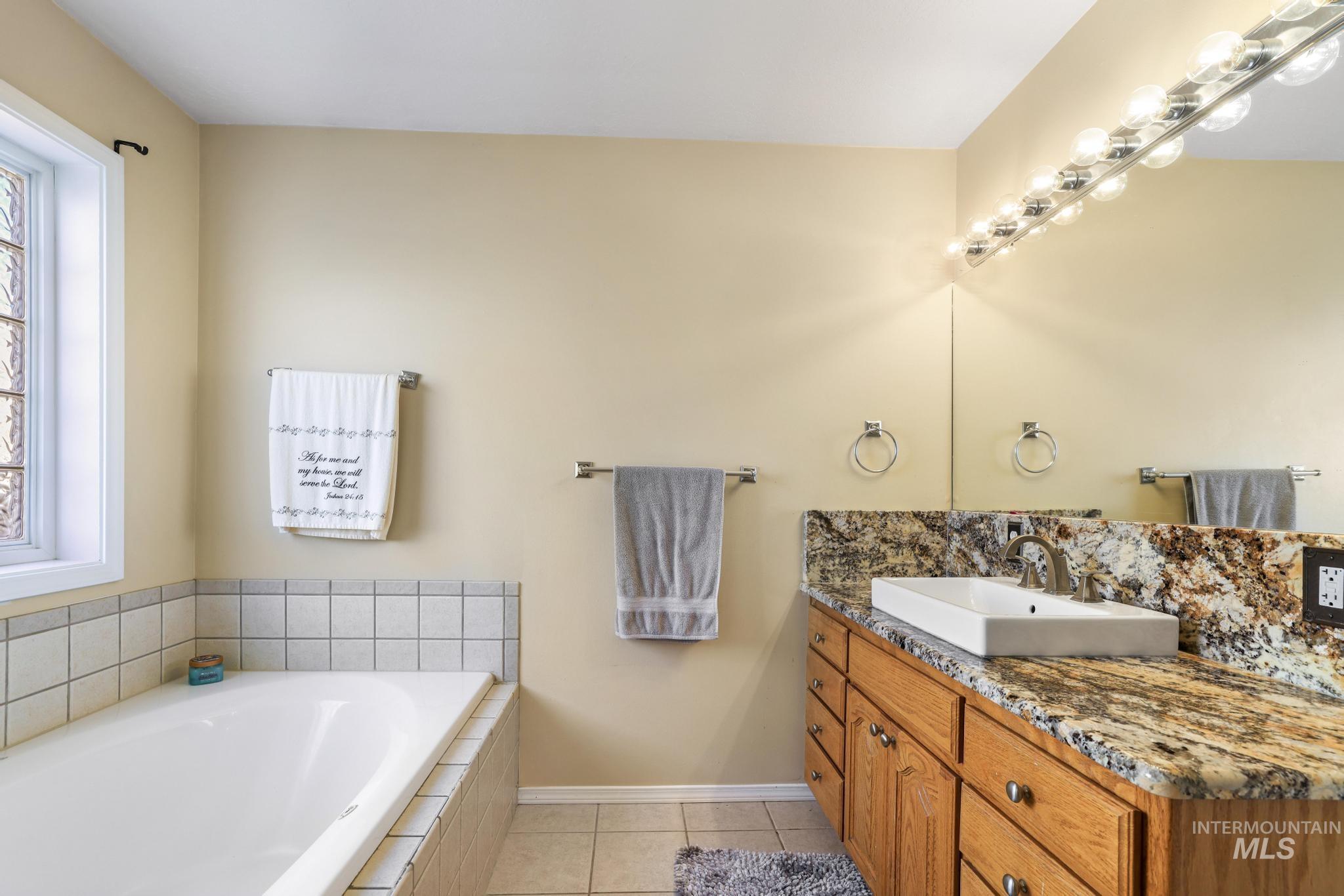 733 Beta Circle Twin Falls, ID 83301 - Photo 22 of 50 Full bathroom featuring vanity, light tile patterned flooring, and a bath