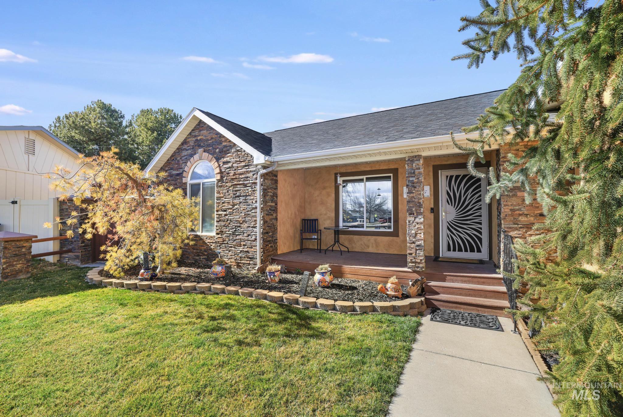 733 Beta Circle Twin Falls, ID 83301 - Photo 4 of 50 View of front facade featuring stone siding, a front yard, roof with shingles, and covered porch